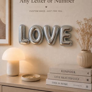 Könnte beinhalten: Silberne Buchstaben im Discokugel-Stil, die das Wort LOVE bilden und an der Wand befestigt sind. Darüber steht der Text Any Letter or Number und CUSTOM MADE. JUST FOR YOU. Die Buchstaben haben eine reflektierende Oberfläche aus kleinen Spiegeln.