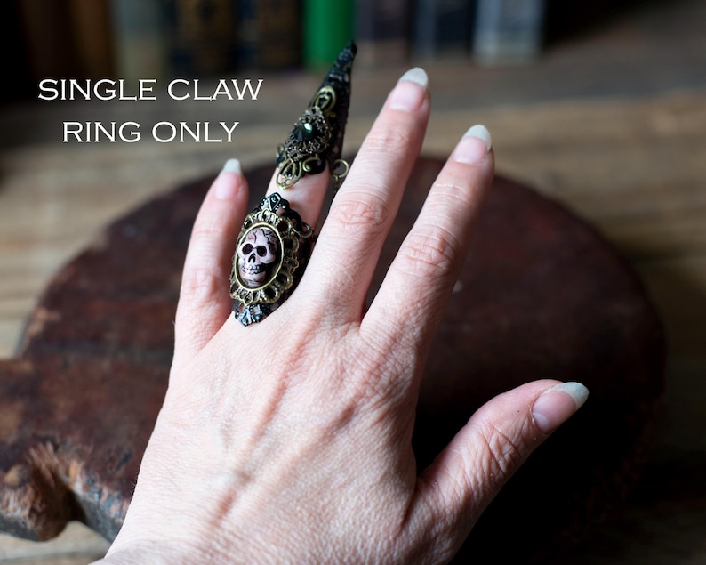 Single claw ring worn on one finger showing adjustable design.