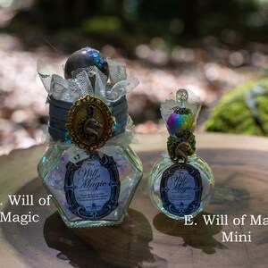Puede incluir: Dos botellas de vidrio con l&iacute;quido iridiscente y tapones decorativos. La botella m&aacute;s grande est&aacute; etiquetada como "The Will of Magic" y la botella m&aacute;s peque&ntilde;a est&aacute; etiquetada como "The Will of Magic Mini".