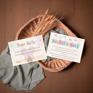 May include: Two baby shower invitation cards with text, "Diaper Raffle" and "Books For Baby", rest on a woven basket with wheat stalks. The cards have pastel colors and whimsical designs, perfect for a baby shower.