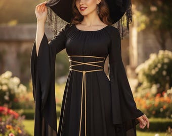 May include: A black floor-length dress with long flared sleeves and a scoop neckline. The dress features a gold cord lacing detail around the waist that hangs down the front. A wide-brimmed black hat with lace trim and a red rose adorns the head.