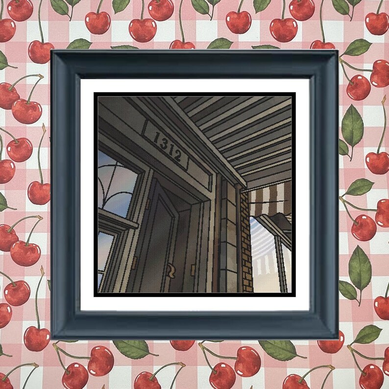 May include: A framed artwork featuring a detailed illustration of a building's entrance, with the number "1312" above the door. The artwork is set against a cherry-patterned background, with a dark blue frame.