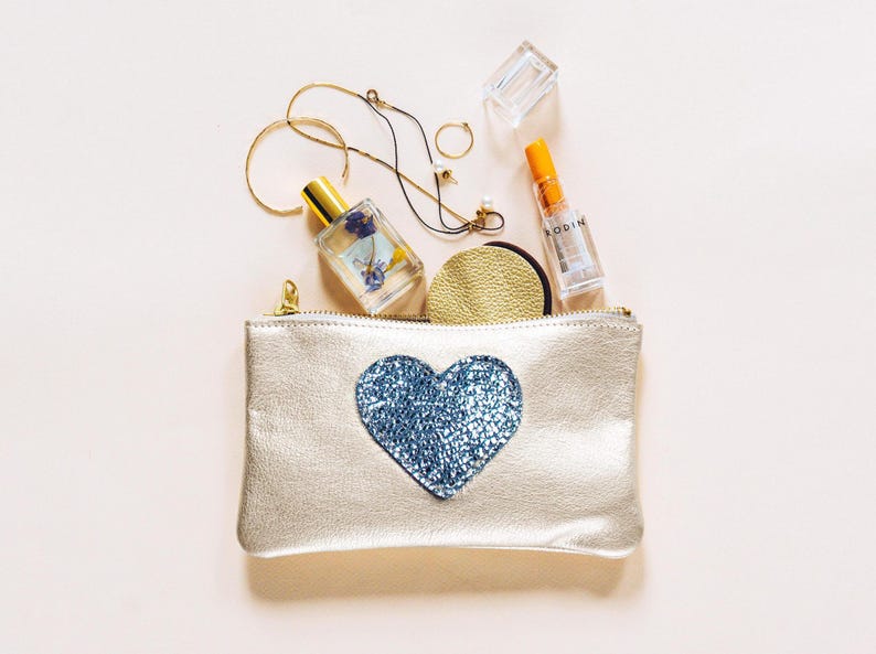 Cartera Be Still My Heart Mae. Cartera de piel en dorado claro. Cartera de piel en color champán metalizado. Cartera de piel con forma de corazón en piel en color platino imagen 1