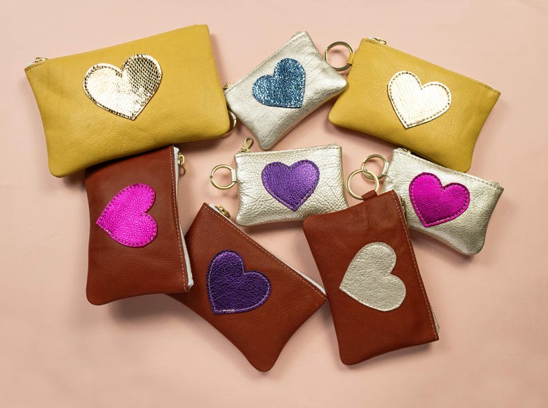 Cartera Be Still My Heart Mae. Cartera de piel en dorado claro. Cartera de piel en color champán metalizado. Cartera de piel con forma de corazón en piel en color platino imagen 4