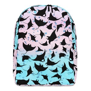 May include: A backpack featuring a repeating pattern of black manta ray silhouettes against a gradient background that transitions from light pink at the top to light blue at the bottom, accented with scattered blue circular spots throughout.