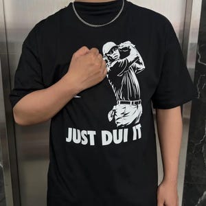 May include: A white ceramic mug with a black handle and the text "But First, Coffee" in a bold, black font. The mug is set against a neutral background, highlighting its simple design.