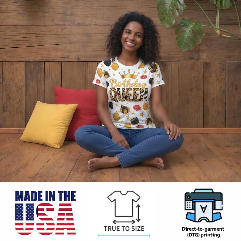May include: White t-shirt with a "Birthday QUEEN" design in gold and leopard print, adorned with gold crowns, gifts, and lip graphics. The shirt is worn by a person sitting on a wooden floor. The text "MADE IN THE USA" is visible.