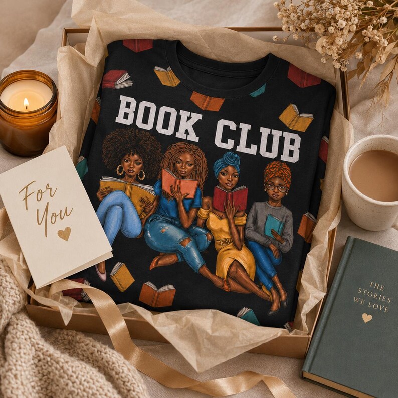 May include: Black crew neck t-shirt with the words "BOOK CLUB" in white. The shirt features an illustration of four women reading books. The shirt is presented in a gift box with a candle, a card that says "For You", and a book.