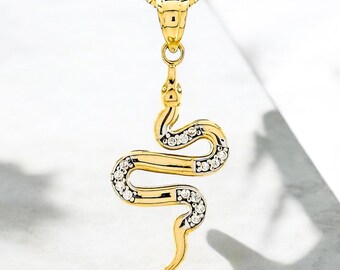 May include: A gold snake pendant necklace with clear cubic zirconia stones. The snake is coiled and has a detailed design.