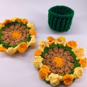Puede incluir: Posavasos de ganchillo hechos a mano y un pequeño portavasos. Los posavasos presentan un diseño de girasol con colores marrón, amarillo y verde. El portavasos es de color verde liso. Estos artículos son perfectos para añadir un toque de encanto artesanal a tu hogar.