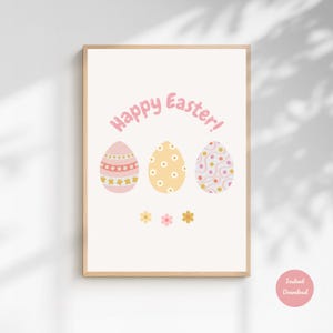 Peut inclure: Une affiche encadrée avec un cadre en bois clair présente trois œufs de Pâques décorés en rose, jaune et blanc, avec les mots "Happy Easter!" en rose au-dessus. De petites fleurs sont en dessous des œufs. Un cercle rose avec les mots "Instant Download" est en bas à droite.