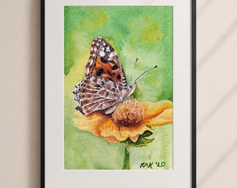 May include: Watercolor painting of a butterfly with brown, orange, and white markings, perched on a yellow flower. The artwork is set against a green and yellow watercolor background, framed in a black frame. The artist's signature "KAK '20" is visible.