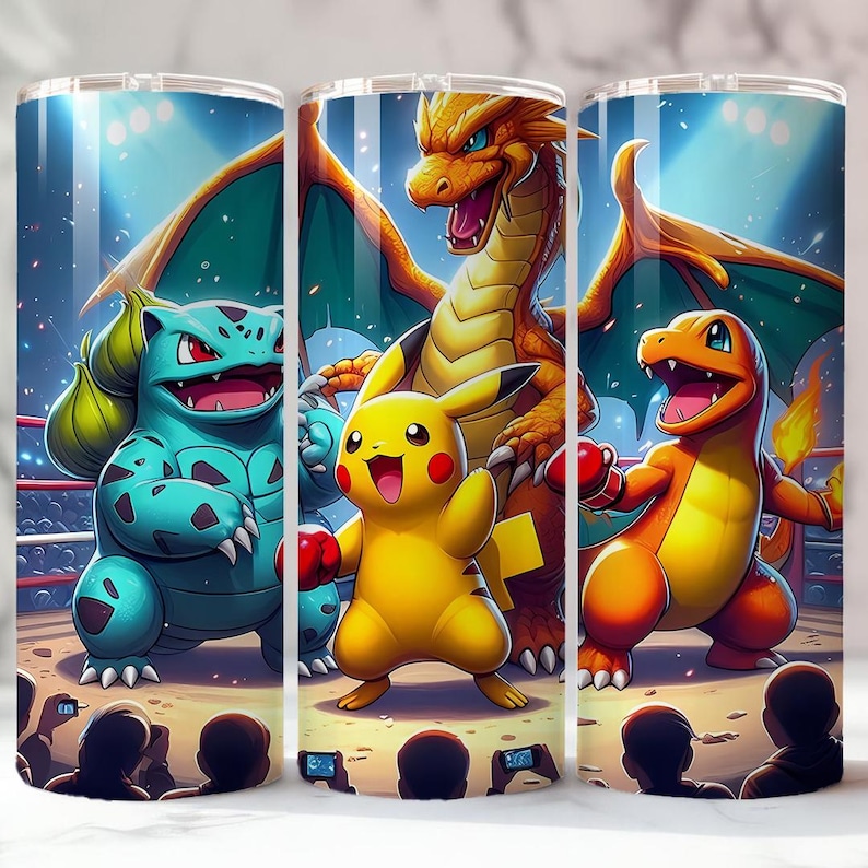 May include: Three stainless steel tumblers with a vibrant illustration of Pokemon characters in a boxing ring. The design features Bulbasaur, Pikachu, Charizard, and Charmander, all wearing boxing gloves. The background includes an audience and spotlights.