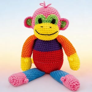 Peut inclure: Une poupée singe au crochet faite à la main. Le singe a une tête rose, des oreilles vertes et un visage jaune avec une bouche souriante. Son corps est rouge, violet et orange, avec des pieds bleus et roses. Un jouet fantaisiste et joyeux.