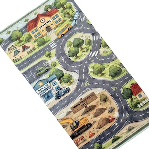 May include: A rectangular play mat featuring a colorful illustrated town map with roads, a school, a police station, and a construction site with an excavator. The design includes green trees, houses, and vehicles like a yellow bus and police car.