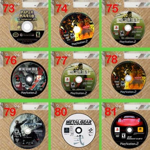 May include: A collection of nine circular video game discs labelled 73 through 81, featuring titles such as Paper Mario, Metal Gear Solid 2, Metal Gear Solid 3, Metal Gear Rising, and Midnight Club II for Nintendo GameCube, PlayStation 2, and PlayStation 3.