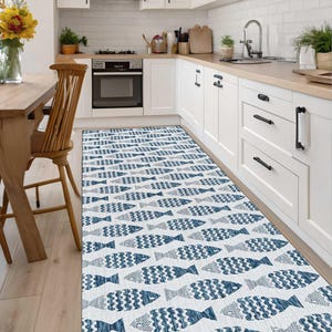May include: A long rectangular runner rug featuring a repeating pattern of blue and white fish. The fish are arranged in horizontal rows across the entire surface of the rug, displaying a textured, woven appearance with varying shades of blue.