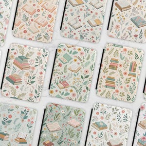 May include: A set of three ceramic mugs with a speckled, cream-colored glaze. Each mug features a different hand-painted floral design in shades of blue, green, and yellow. The mugs have a simple, modern shape.