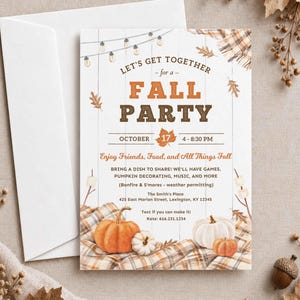 May include: A white invitation card with a wood plank background featuring string lights, orange and white pumpkins, and a plaid blanket. The text reads: LET'S GET TOGETHER for a FALL PARTY OCTOBER 17 4 - 8:30 PM Enjoy Friends, Food, and All Things Fall.