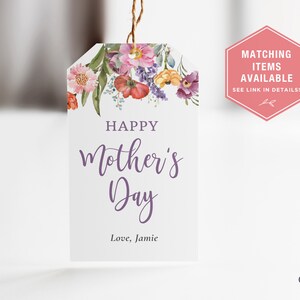 May include: A white gift tag with a watercolor floral design in shades of pink, purple, yellow, and orange. The tag reads "Happy Mother's Day" in purple script and "Love, Jamie" in black text.