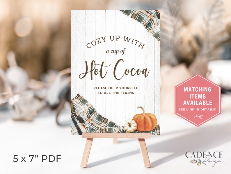 Puede incluir: Un caballete de madera muestra un letrero que dice "Cozy up with a cup of Hot Cocoa". El letrero presenta un dise&ntilde;o a cuadros, calabazas y el texto "Please help yourself to all the fixins". Un gr&aacute;fico hexagonal rosa dice "Matching Items Available."