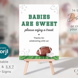Może przedstawiać: Biały znak na drewnianym sztaludze z napisem "BABIES ARE SWEET" w kolorze zielonym i białym. Piłka nożna i buciki dla dziecka na dole. Znak głosi "please enjoy a treat" i "Thanks for celebrating with us!"