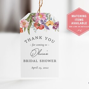 Op de afbeelding: Een wit bedankkaartje met een bloemenontwerp in roze, rood en gele tinten. Het kaartje zegt "Bedankt - voor het komen naar - Olivia's bruiloftsshower op 23 april 2022".