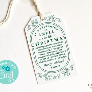 May include: White gift tag with green holly leaves and berries. The tag has a green oval with the text "It's beginning to smell a lot like Christmas". The text continues with instructions for making a Christmas-scented simmer pot.