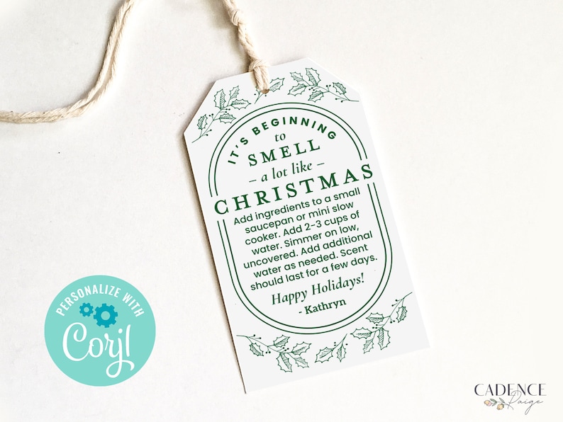 May include: White gift tag with green holly leaves and berries. The tag has a green oval with the text "It's beginning to smell a lot like Christmas". The text continues with instructions for making a Christmas-scented simmer pot.