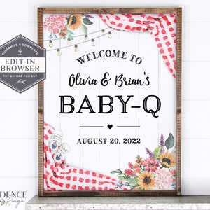 May include: A white wooden sign with a red and white checkered pattern and floral accents. The sign says "Welcome to Olivia & Brian's Baby-Q August 20, 2022".
