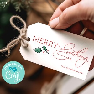 May include: A white gift tag with red text that says "Merry Everything" in cursive. A small green holly sprig with red berries is in the upper left corner. The text "From the Wilsons | 2023" is in the lower right corner.