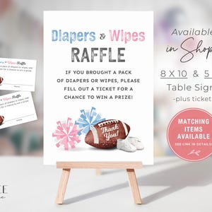 May include: A white sign with blue and pink text that reads "Diapers & Wipes Raffle". The sign has a football, cheerleaders pom-poms, and baby shoes. The sign also says "If you brought a pack of diapers or wipes, please fill out a ticket for a chance to win a prize!" and "Available in Shop! 8 x 10 & 5 x 7 Table Signs -plus tickets Matching Items Available See link in details!"