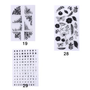 May include: Clear stamps with decorative corner designs, floral and butterfly motifs, and alphabet letters and numbers. The stamps are labeled with the numbers 19, 28, and 29.