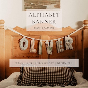 May include: A handmade alphabet banner spelling "OLIVER" hangs against a wooden headboard. Each fabric letter has a unique pattern, including stripes and checks. The banner is part of a sewing pattern, with text that reads "TWO SIZES | ZERO WASTE | BEGINNER".