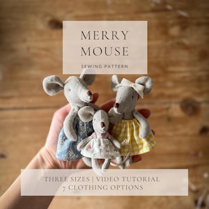 May include: Three gray fabric mouse dolls in dresses, held in a hand. The mice have large ears and small noses. The dresses are patterned in blue, yellow, and floral prints. The text reads "MERRY MOUSE SEWING PATTERN" and "THREE SIZES | VIDEO TUTORIAL | 7 CLOTHING OPTIONS."