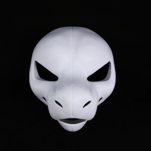 May include: A plain white animal mask, possibly a reptile or canine, with a prominent snout. It features large, angular eye openings and small holes near the snout. The mask is made of a smooth material and is set against a black backdrop.
