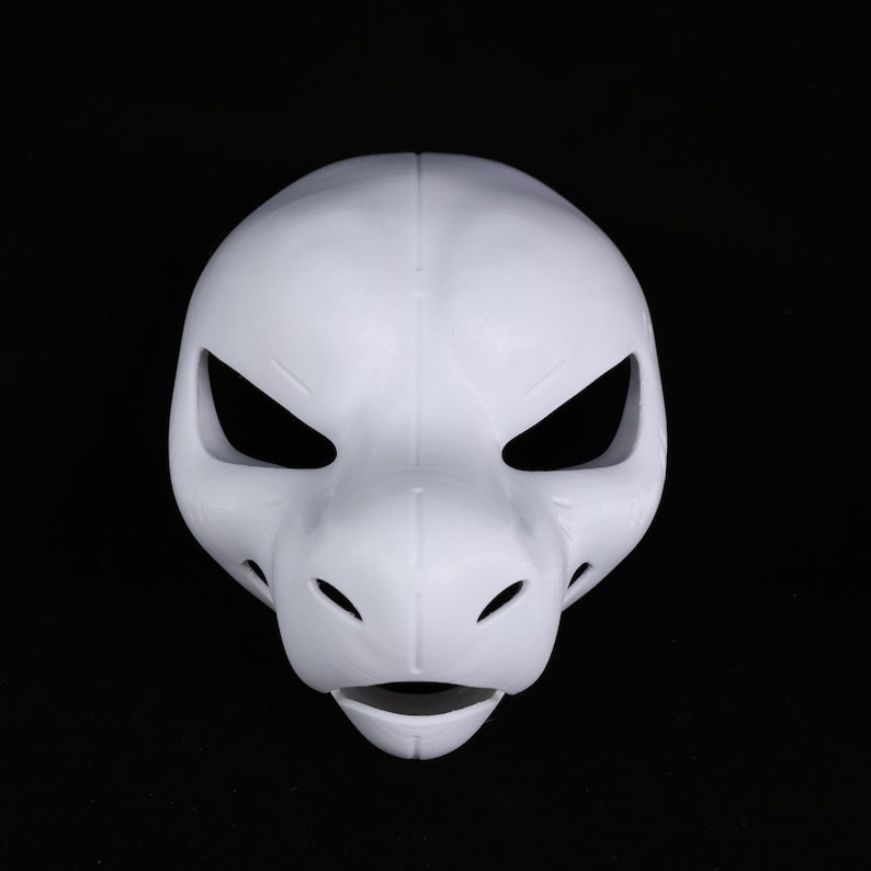 May include: A plain white animal mask, possibly a reptile or canine, with a prominent snout. It features large, angular eye openings and small holes near the snout. The mask is made of a smooth material and is set against a black backdrop.