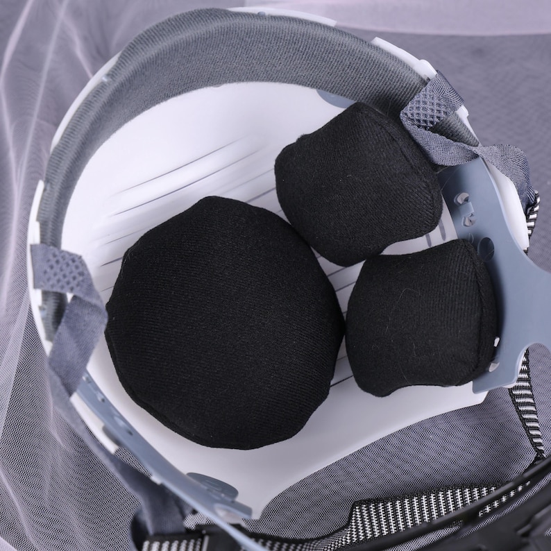 May include: Close-up of the interior of a white safety helmet with black padding. The helmet has a gray rim and adjustable straps. The image is well-lit, showing the details of the protective gear.