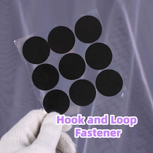 May include: A sheet of black hook and loop fastener circles. The circles are held in a clear plastic sheet. The text "Hook and Loop Fastener" is printed in purple and white.
