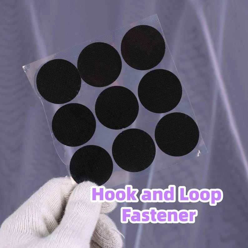 May include: A sheet of black hook and loop fastener circles. The circles are held in a clear plastic sheet. The text "Hook and Loop Fastener" is printed in purple and white.