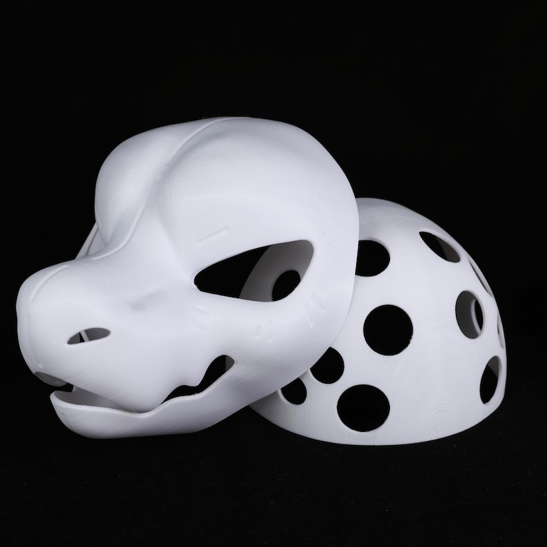 May include: A white, unpainted fursuit head and back piece. The head features a stylized animal design with large eye openings and a detailed snout. The back piece has multiple circular cutouts. The items are set against a black background.
