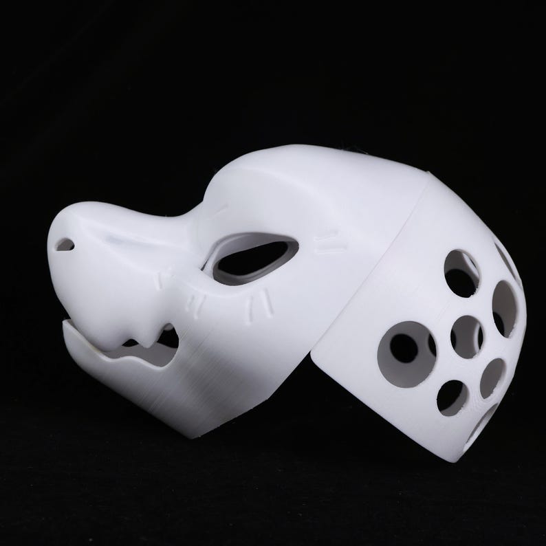 May include: A white, 3D-printed mask with a canine-like snout and eye openings. The mask features several circular ventilation holes on the side and vertical lines on the snout. The mask is designed for cosplay or costume use.