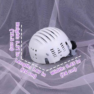 May include: White helmet with a vented design. The helmet is 5.31 inches (13.5 cm) high, 7.87 inches (20 cm) long, and 9.45 inches (24 cm) wide. It features a chin strap and a black adjustment mechanism.