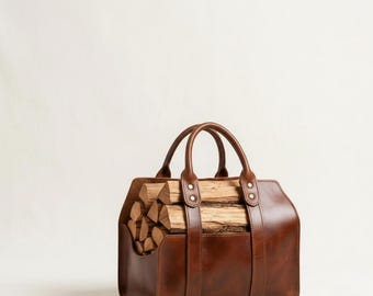May include: A brown leather log carrier with two rounded handles and riveted accents. The bag is filled with cut firewood. The carrier has a rectangular shape and a vertical strap on the front.