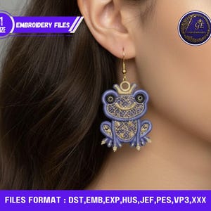 Peut inclure: Boucle d'oreille unique avec un motif de grenouille violette et des détails dorés. La grenouille porte une couronne et présente des broderies détaillées. Le texte "EMBROIDERY FILES" et "FILES FORMAT: DST, EMB, EXP, HUS, JEF, PES, VP3,XXX" sont visibles.