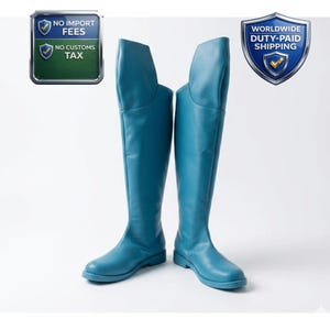 Puede incluir: Un par de botas altas de color turquesa. Las botas tienen un acabado liso y mate y una puntera redondeada. Las botas se muestran sobre un fondo blanco. La imagen también incluye texto que dice "No Import Fees" y "No Customs Tax".