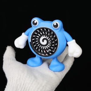 Pode incluir: Um personagem de desenho animado azul com um design em espiral no peito, luvas brancas e olhos grandes. O personagem tem um corpo redondo e fica em p&eacute; sobre dois p&eacute;s. O fundo &eacute; preto.