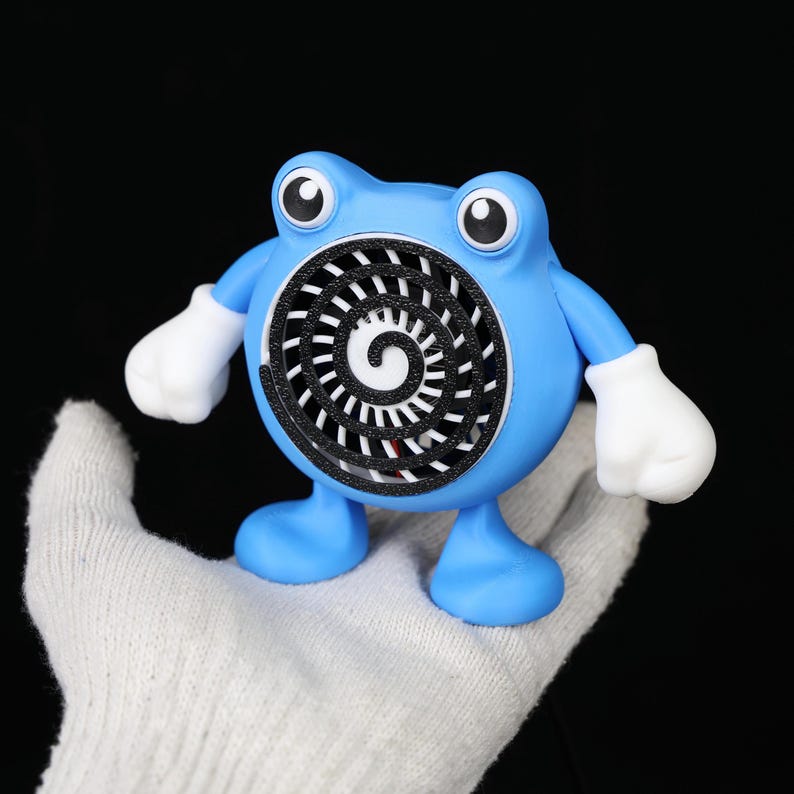 Pode incluir: Um personagem de desenho animado azul com um design em espiral no peito, luvas brancas e olhos grandes. O personagem tem um corpo redondo e fica em p&eacute; sobre dois p&eacute;s. O fundo &eacute; preto.