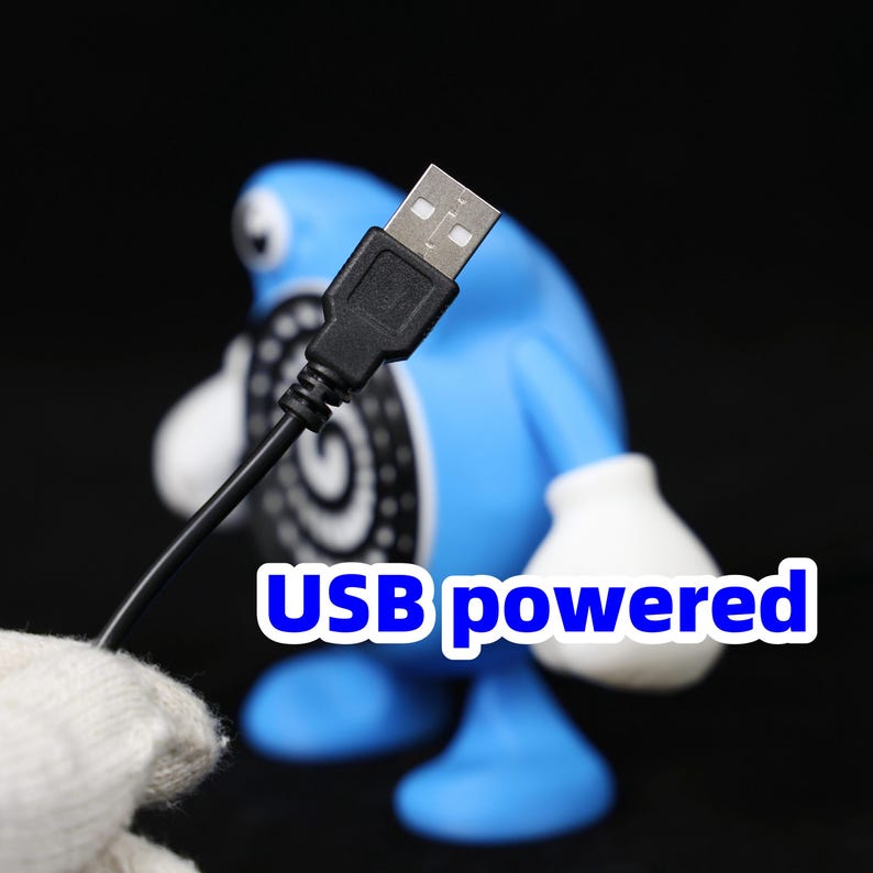 Pode incluir: Uma figura azul com luvas e p&eacute;s brancos, e um design em preto e branco no torso. Um cabo USB preto est&aacute; conectado &agrave; figura. O texto "USB powered" &eacute; exibido em branco e azul.