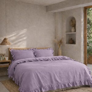 May include: A bedroom with a bed dressed in lavender bedding with a ruffled edge. The room has a neutral colour scheme. A natural fibre rug is on the floor. The bed has a wooden headboard. The duvet cover and pillowcases are lavender.